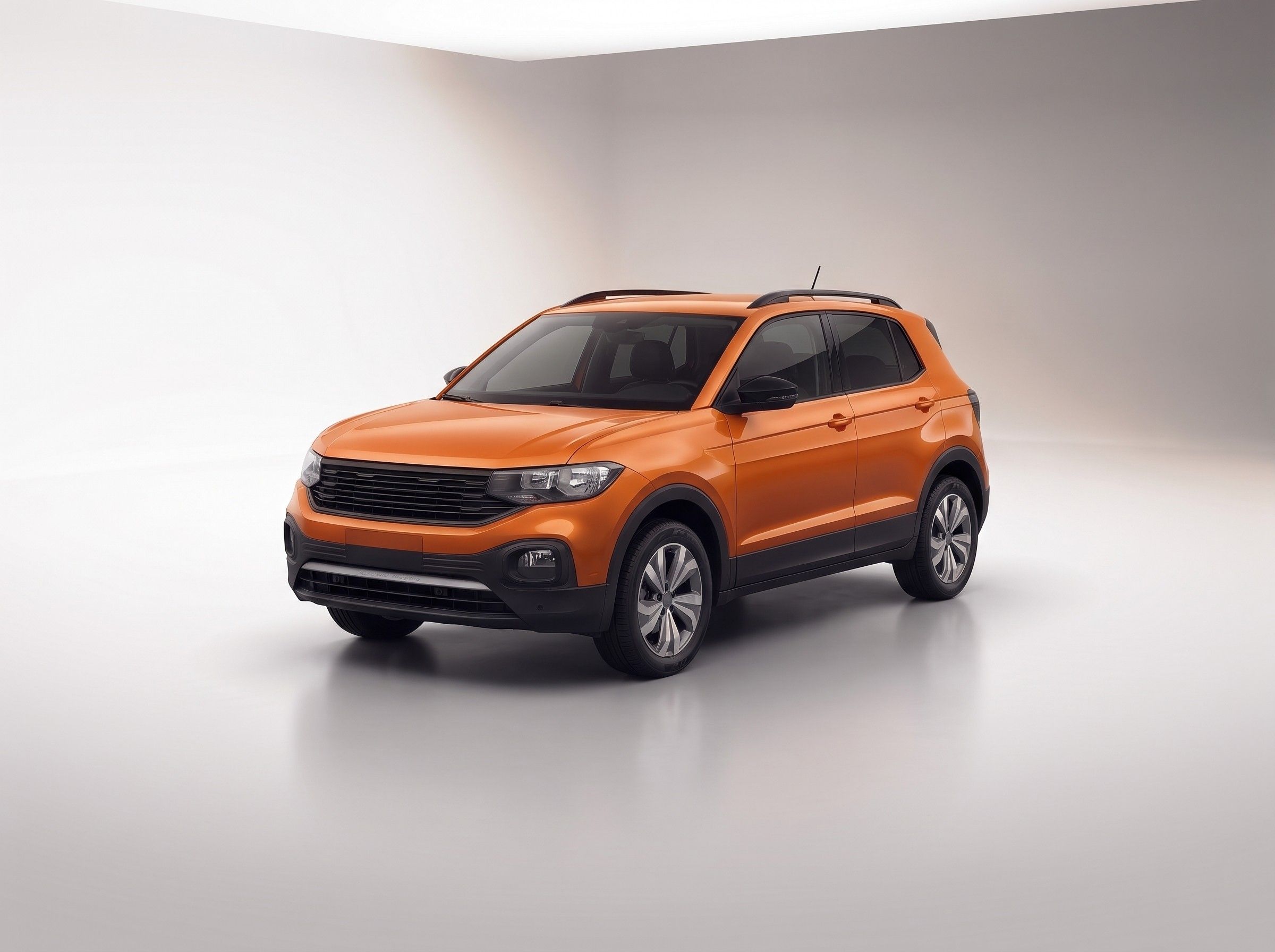 SUV compacto laranja sem logotipo, em vista três quartos, num estúdio claro.